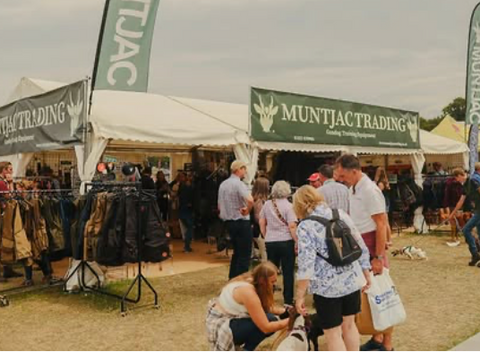 Outdoor event with Muntjac Trading booth and people around